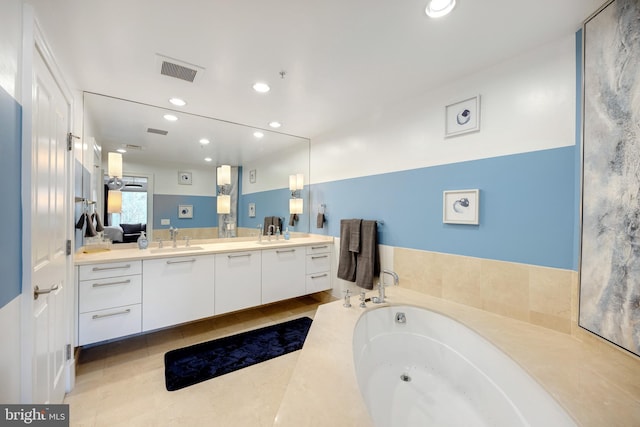 bathroom featuring vanity, tile patterned flooring, and a bathing tub