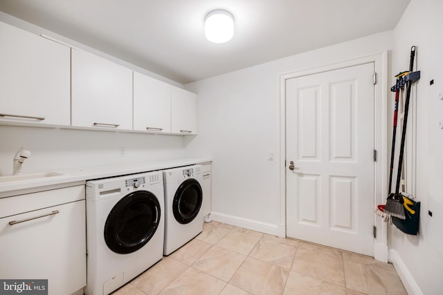 laundry room featuring cabinets, light tile patterned floors, washer and clothes dryer, and sink