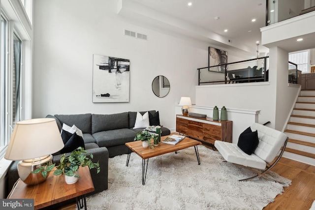 living room with a high ceiling and light wood-type flooring