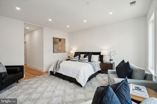 bedroom with multiple windows and light hardwood / wood-style floors