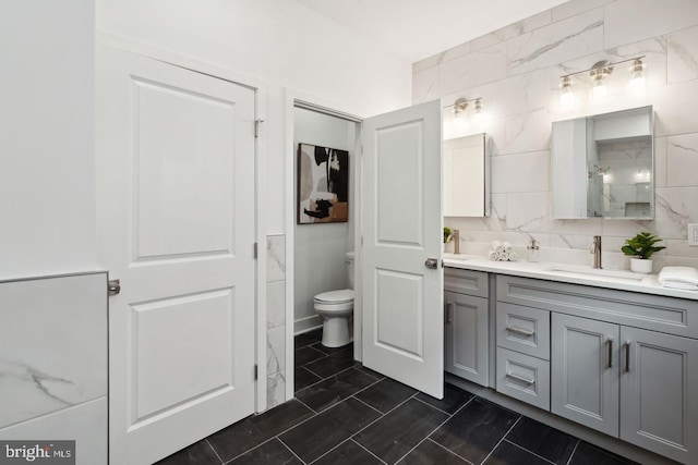 bathroom featuring vanity, toilet, and decorative backsplash