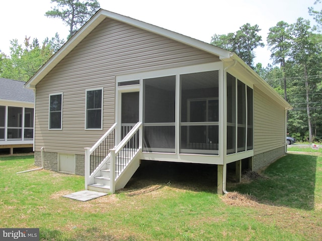 back of house with a lawn and a sunroom