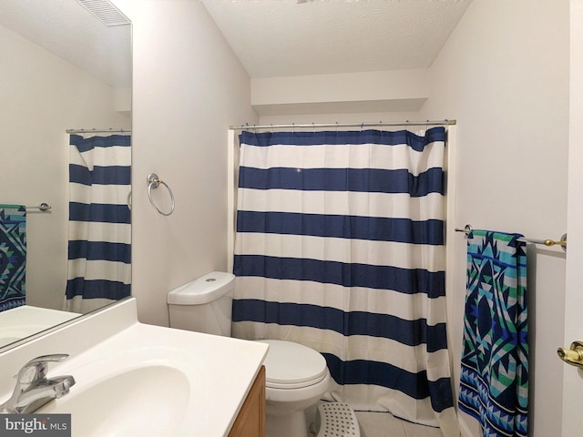 bathroom featuring vanity, tile patterned floors, toilet, a textured ceiling, and walk in shower