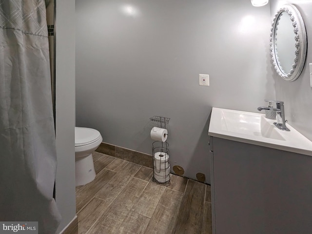 bathroom with vanity, hardwood / wood-style flooring, and toilet