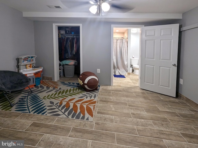 interior space with ensuite bathroom, ceiling fan, a spacious closet, and a closet