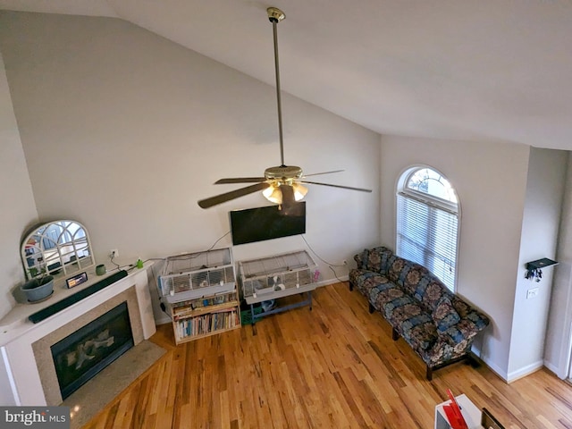 living room featuring ceiling fan, light hardwood / wood-style floors, and high vaulted ceiling