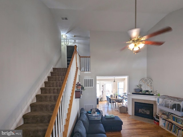 living room with ceiling fan, wood-type flooring, and vaulted ceiling