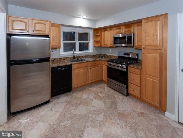 kitchen featuring sink, dark stone counters, and appliances with stainless steel finishes