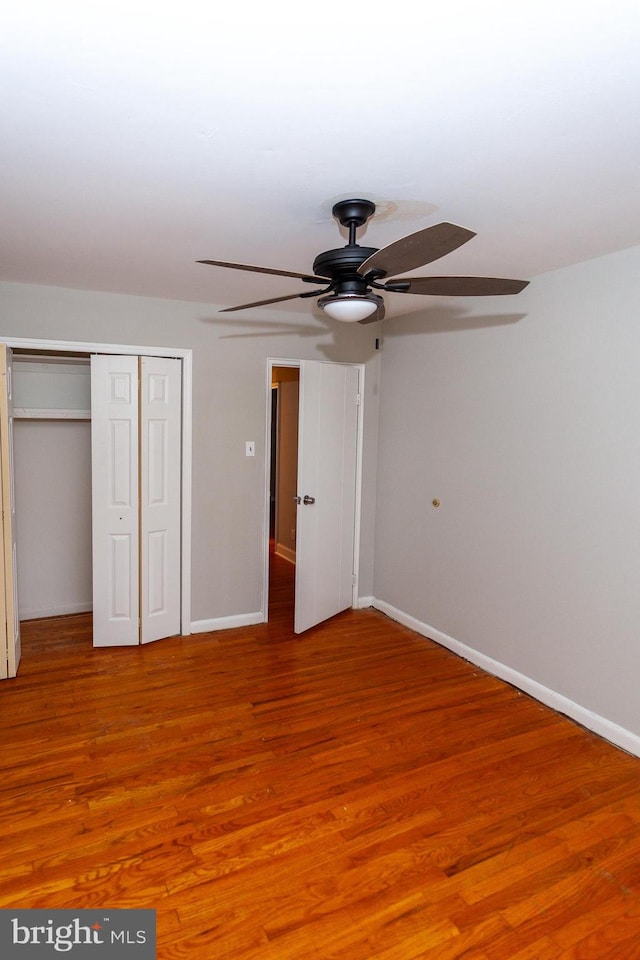 unfurnished bedroom with a closet, ceiling fan, and hardwood / wood-style floors