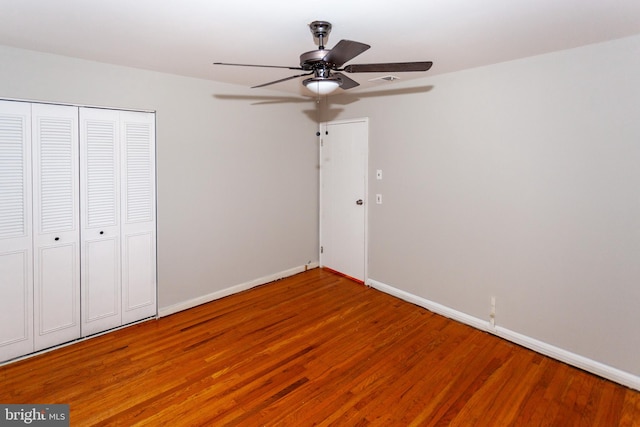 unfurnished bedroom with ceiling fan, a closet, and wood-type flooring