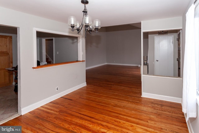 unfurnished dining area with hardwood / wood-style flooring and an inviting chandelier