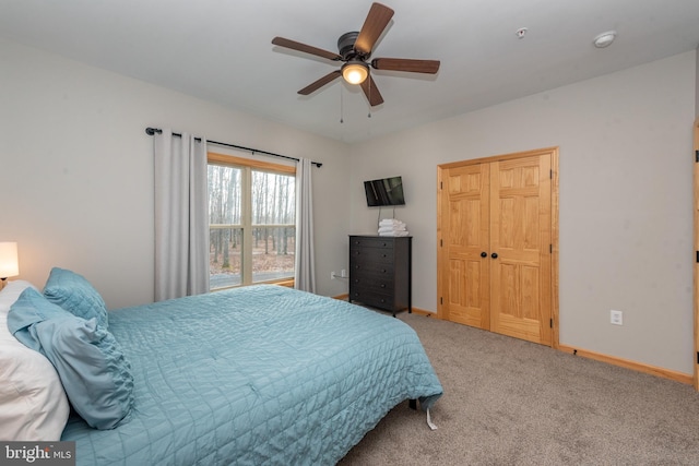 carpeted bedroom with ceiling fan and a closet