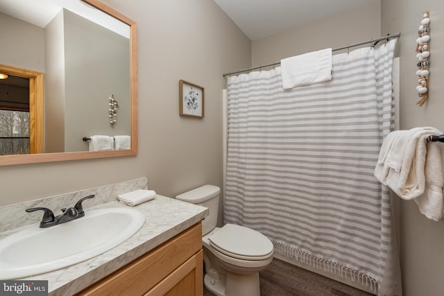 bathroom featuring wood-type flooring, vanity, and toilet