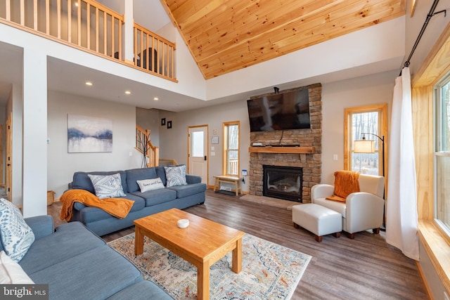 living room with a fireplace, wood-type flooring, wood ceiling, and high vaulted ceiling