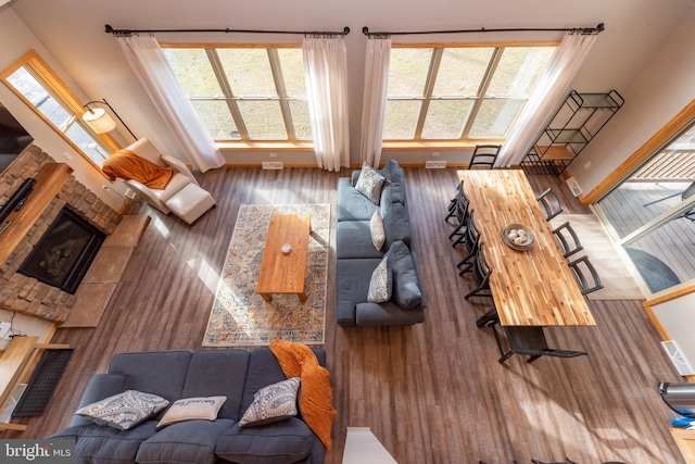 living room featuring a stone fireplace and hardwood / wood-style flooring