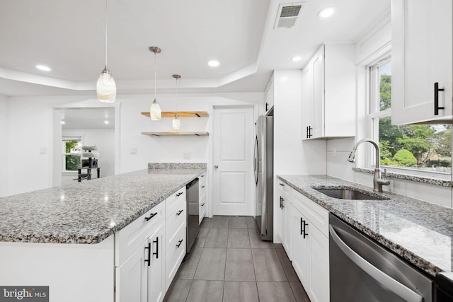 kitchen featuring stainless steel appliances, white cabinetry, light stone countertops, hanging light fixtures, and sink