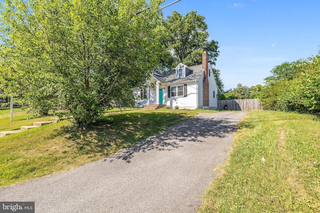 cape cod home featuring a front yard