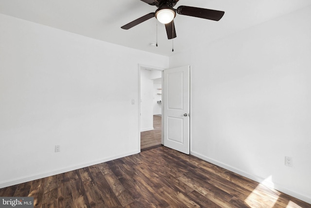 spare room with dark hardwood / wood-style flooring and ceiling fan