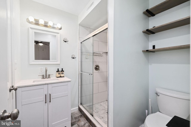 bathroom with vanity, toilet, and a shower with shower door