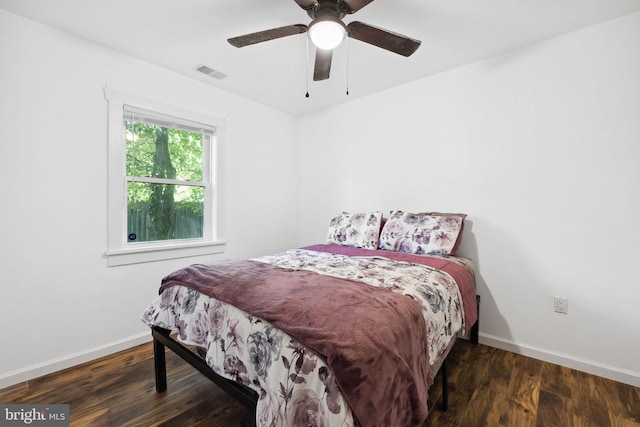 bedroom with dark hardwood / wood-style flooring and ceiling fan