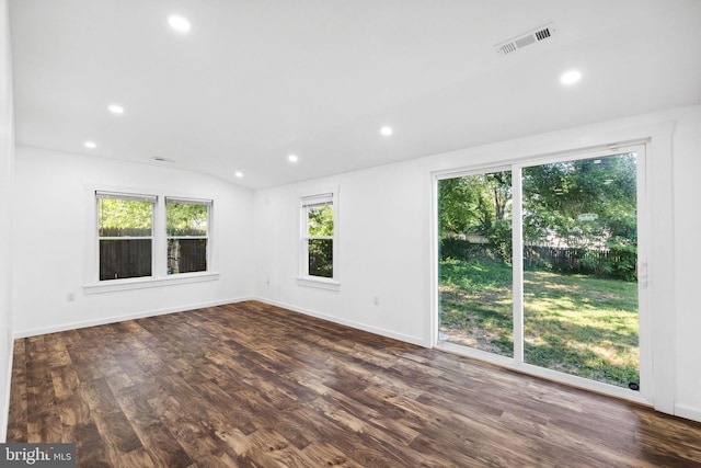 empty room with dark wood-type flooring and vaulted ceiling