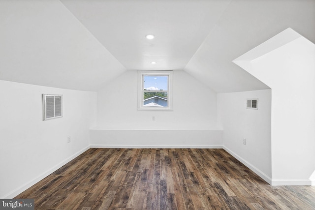 additional living space featuring vaulted ceiling and dark hardwood / wood-style flooring