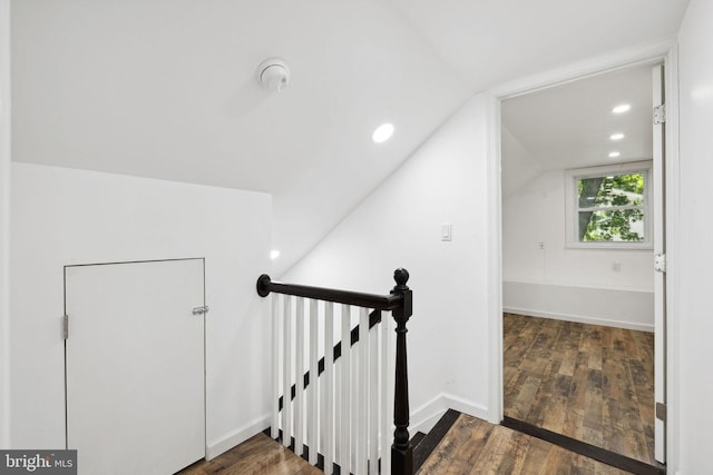 stairway featuring wood-type flooring and vaulted ceiling