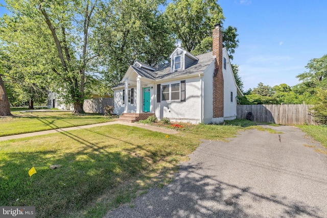 cape cod home featuring a front lawn