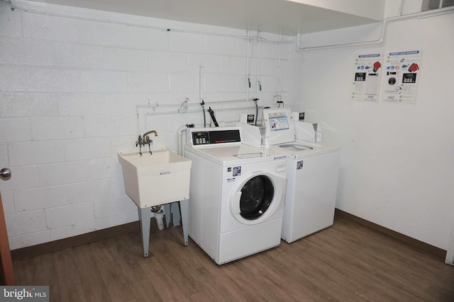 clothes washing area with washing machine and clothes dryer and dark hardwood / wood-style flooring