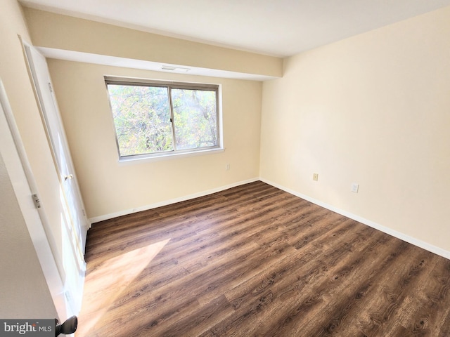 empty room with dark wood-type flooring