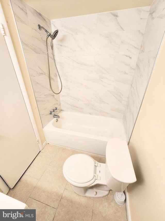 bathroom featuring toilet, tiled shower / bath combo, and tile patterned flooring