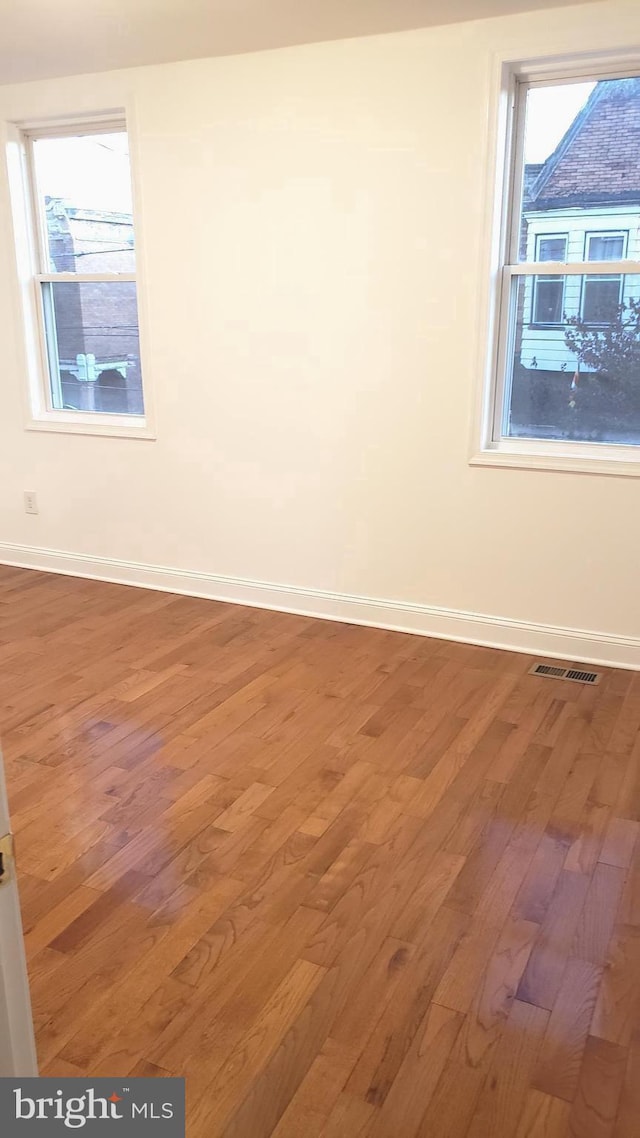 unfurnished room with wood-type flooring