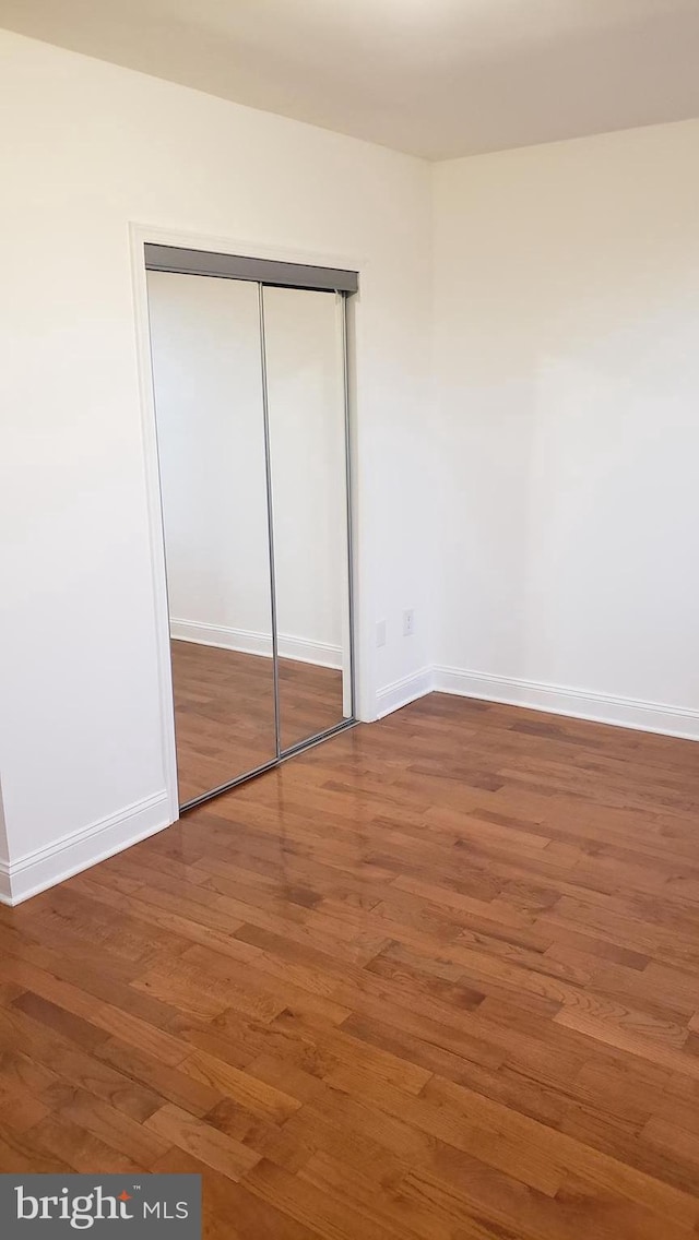 unfurnished bedroom featuring hardwood / wood-style flooring and a closet