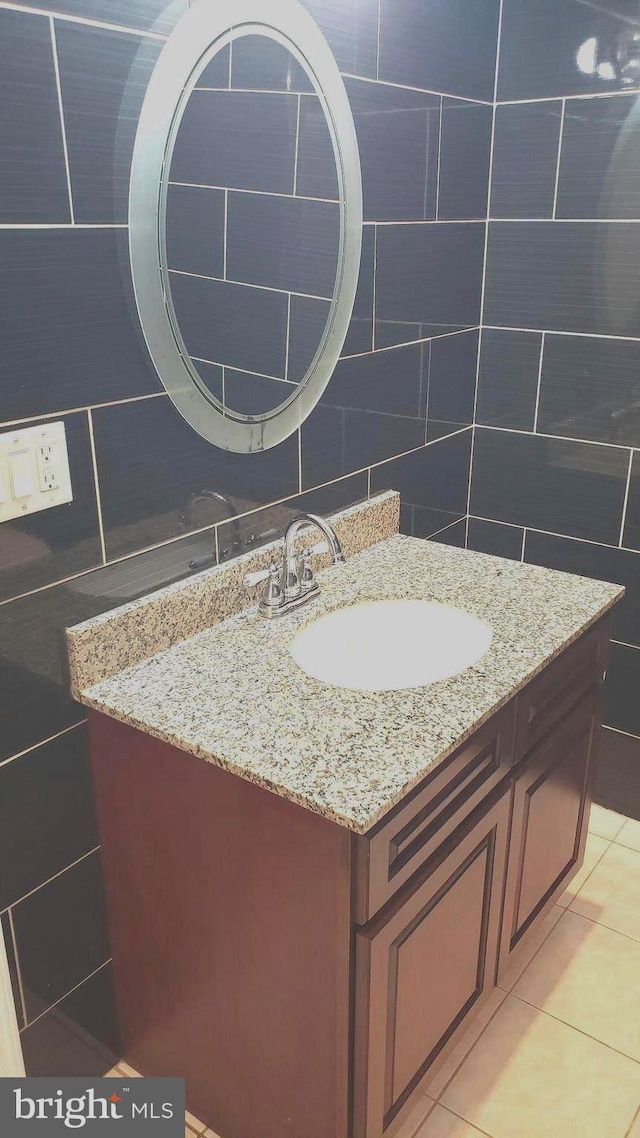 bathroom with tile patterned flooring, backsplash, tile walls, and vanity