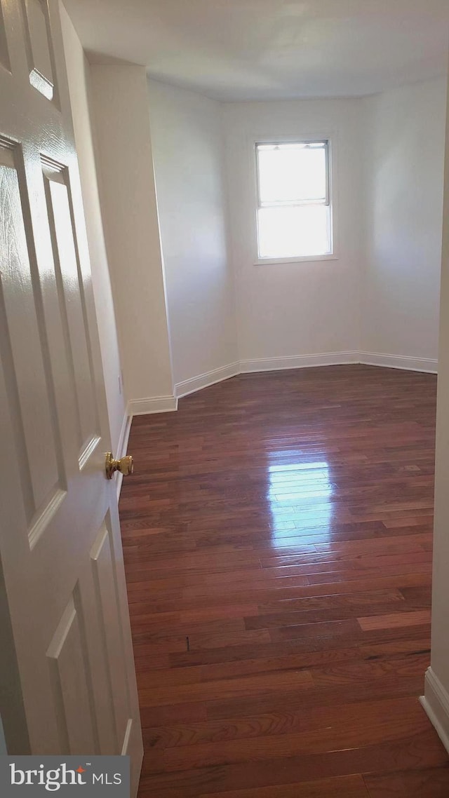 spare room featuring dark wood-type flooring