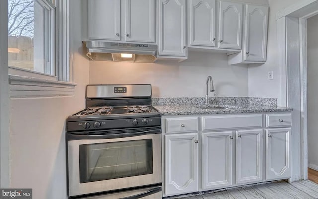 kitchen with white cabinetry, light stone countertops, sink, gas range, and light hardwood / wood-style flooring