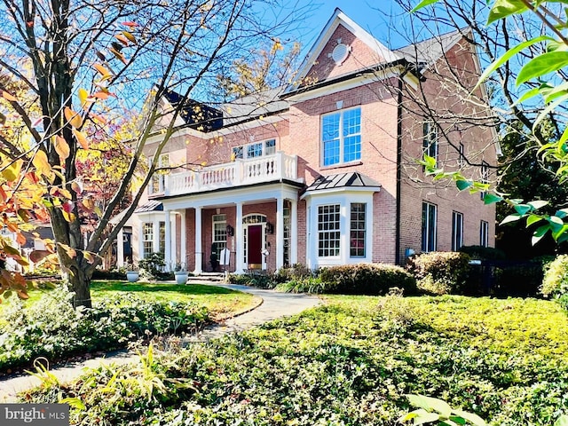 view of front of property with a balcony and a front lawn