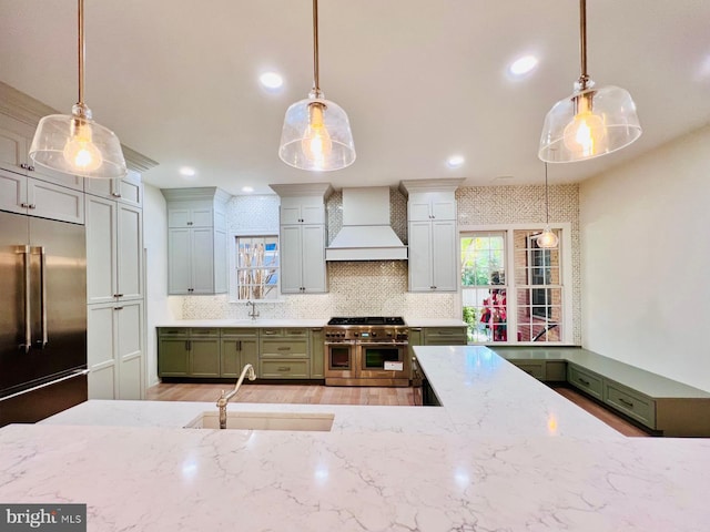 kitchen with custom range hood, premium appliances, and pendant lighting