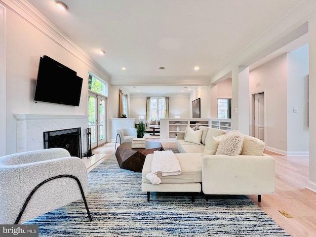 living room with ornamental molding, a premium fireplace, and light hardwood / wood-style floors