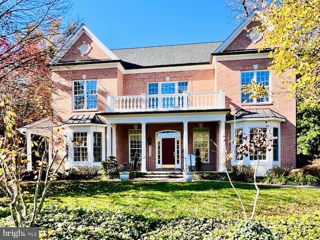 view of front of property featuring a front yard and a balcony