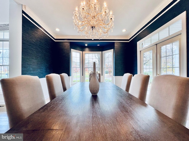 dining space with ornamental molding and a chandelier