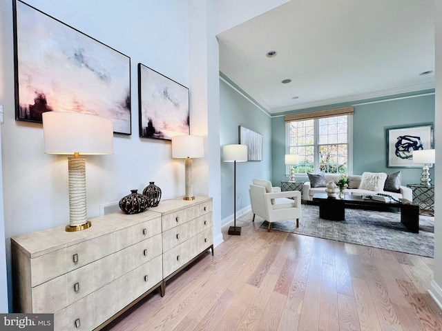 living area with light wood-type flooring and crown molding