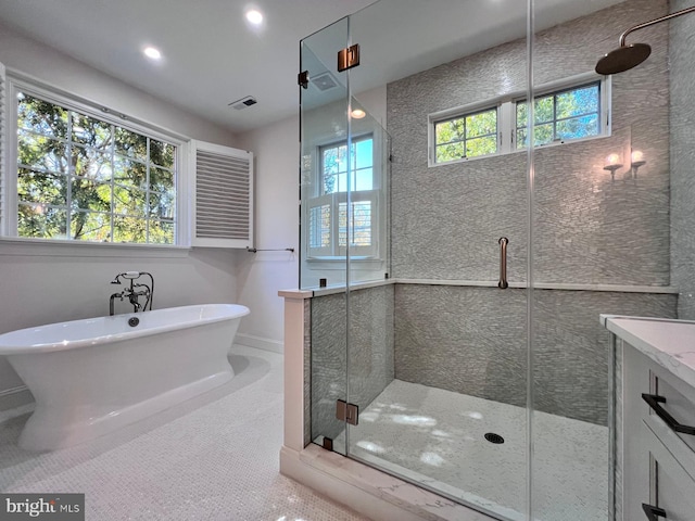 bathroom featuring shower with separate bathtub, vanity, and tile patterned floors