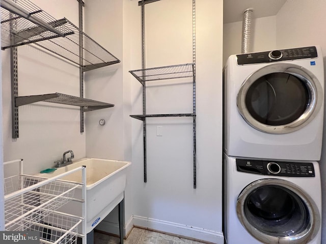 clothes washing area with stacked washer / dryer