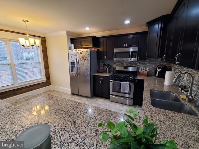 kitchen with sink, stainless steel appliances, crown molding, a chandelier, and decorative light fixtures