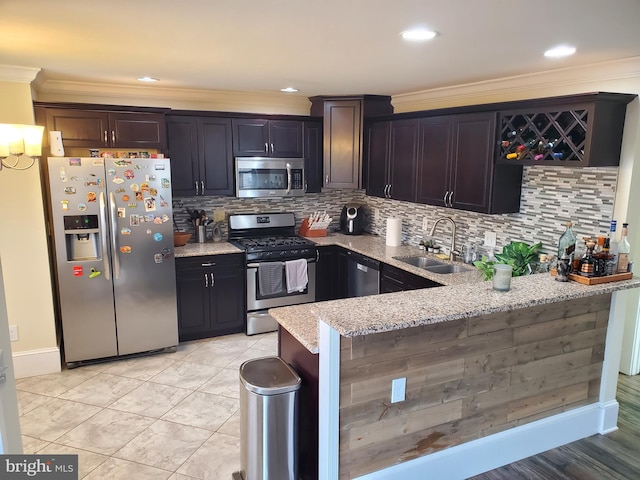 kitchen featuring light stone countertops, appliances with stainless steel finishes, tasteful backsplash, crown molding, and sink