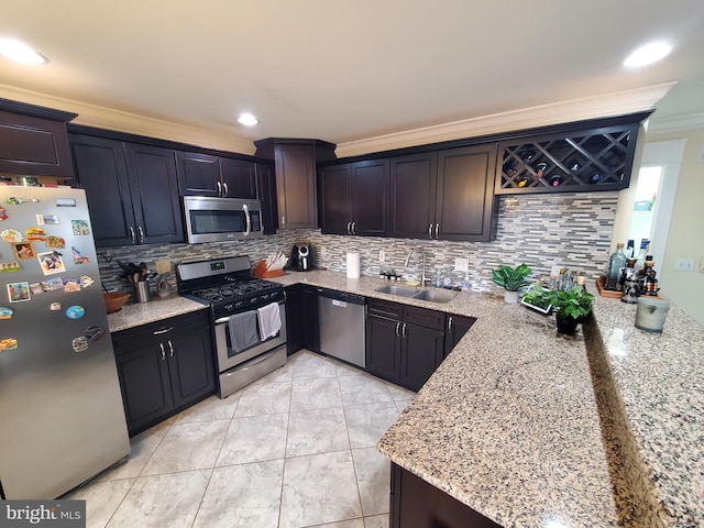 kitchen with light stone countertops, tasteful backsplash, stainless steel appliances, crown molding, and sink