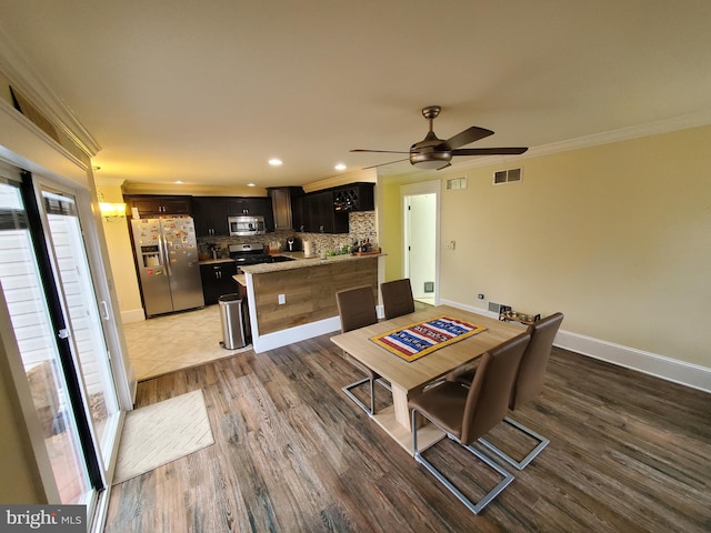 dining space featuring ceiling fan with notable chandelier, crown molding, and dark wood-type flooring