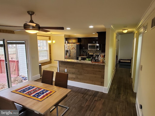 dining area with dark hardwood / wood-style flooring, ceiling fan with notable chandelier, and ornamental molding