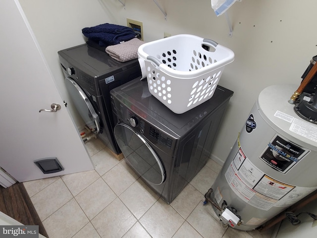 washroom featuring water heater, light tile patterned floors, and washer hookup